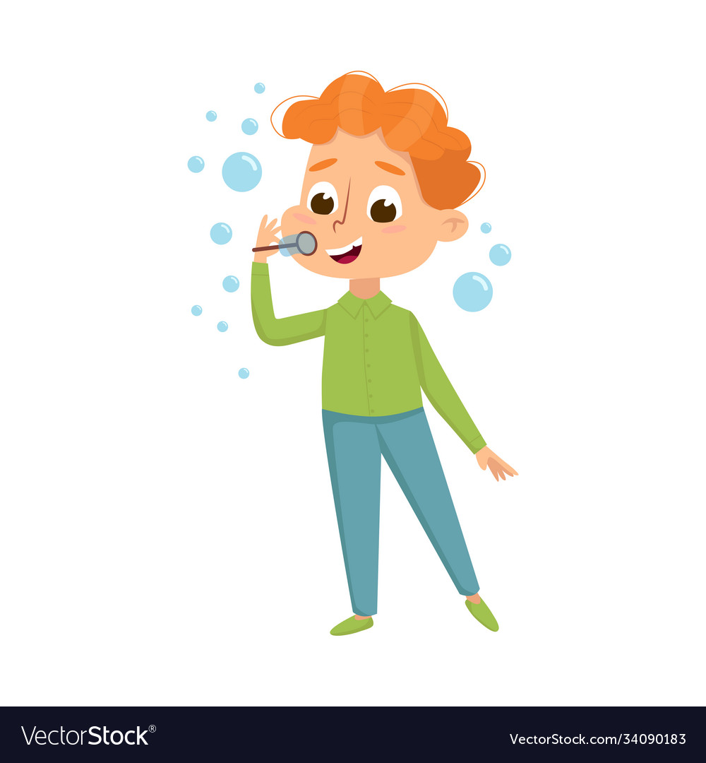 Cute redhead boy blowing soap bubbles through wand