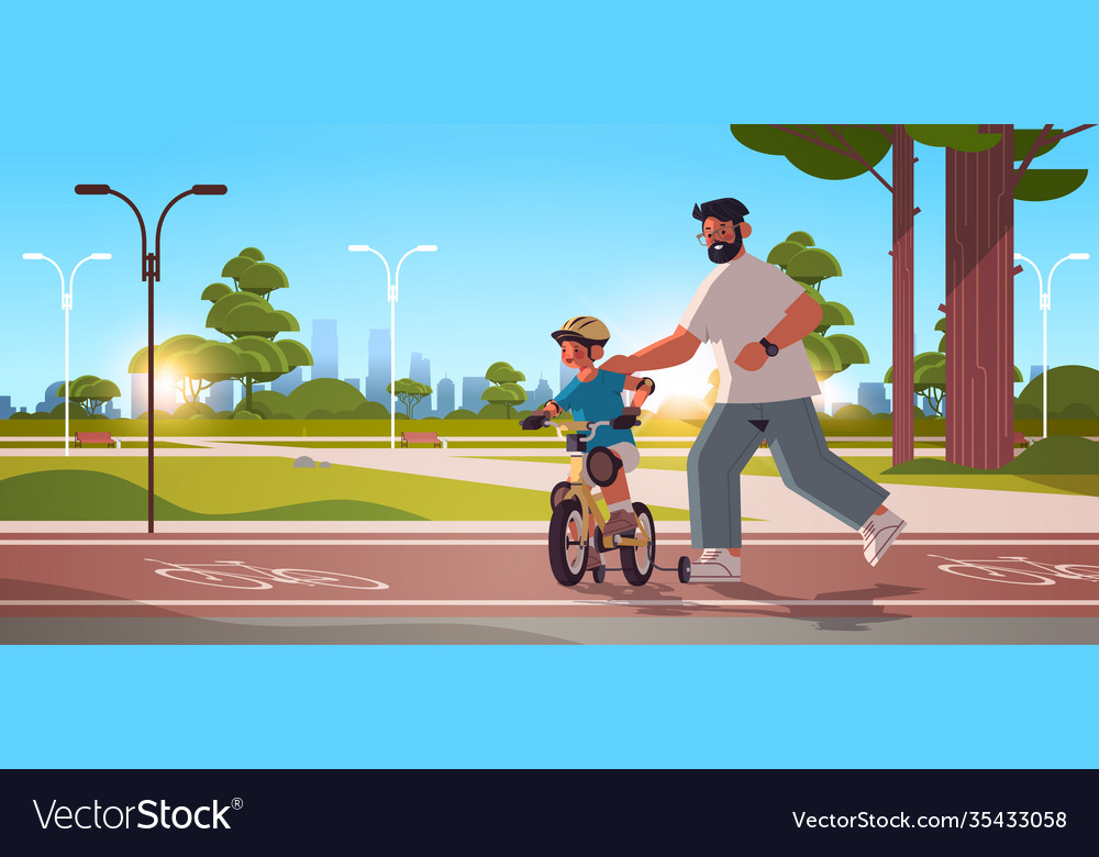 Father teaching little son to ride bike in urban