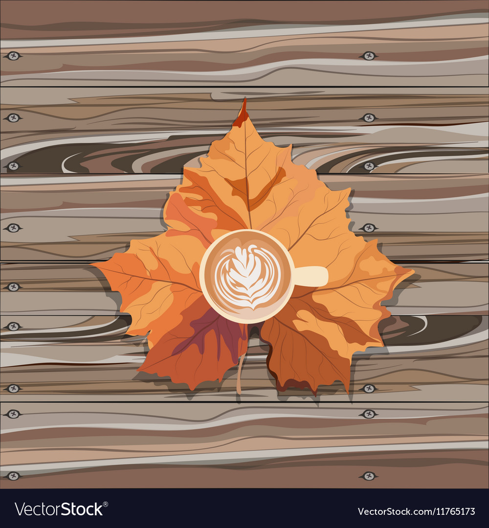 Hot steaming cup of coffee and autumn leaf