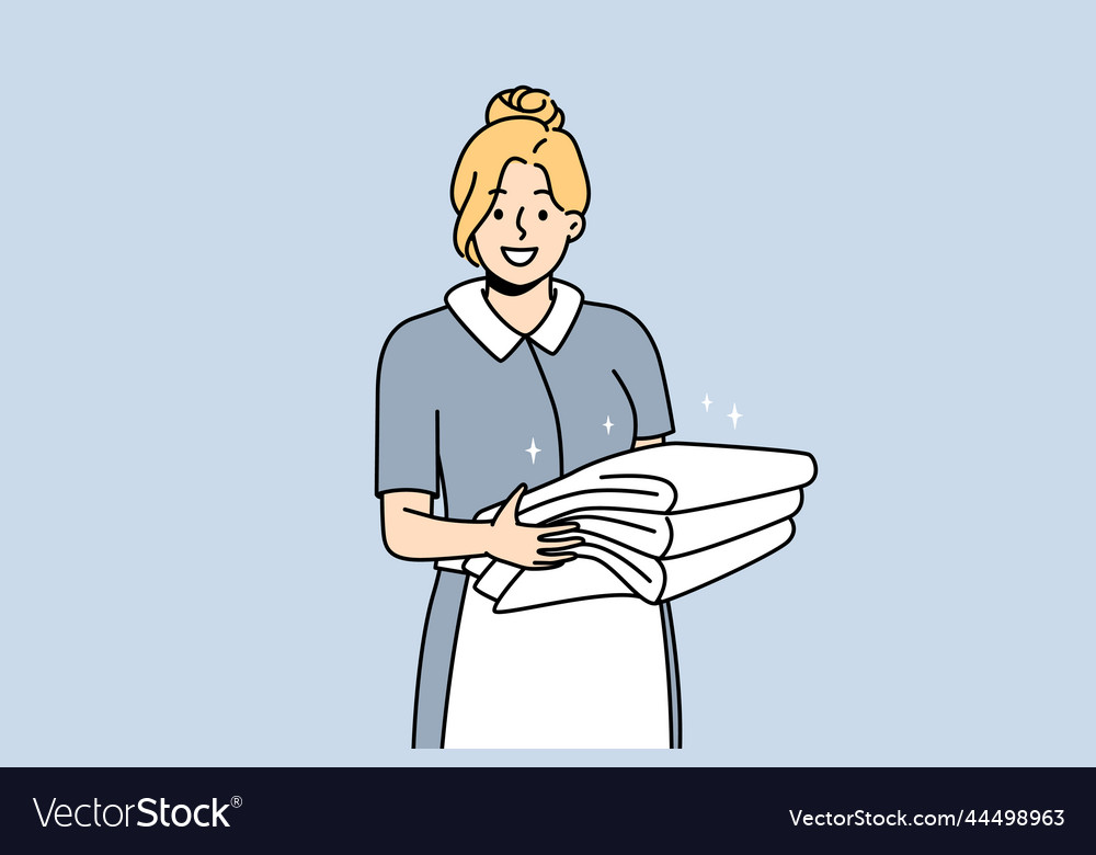 Smiling housekeeper with stack of towels