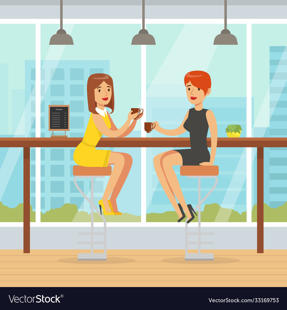 Two young women sitting in cafe and drinking