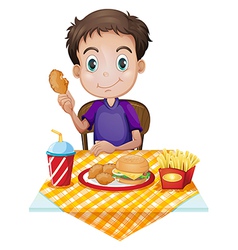 A curly-haired boy eating at a fastfood restaurant