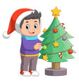 cartoon little boy decorating a christmas tree vector image vector image