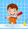 Cute little boy brushing teeth in bathroom Vector Image